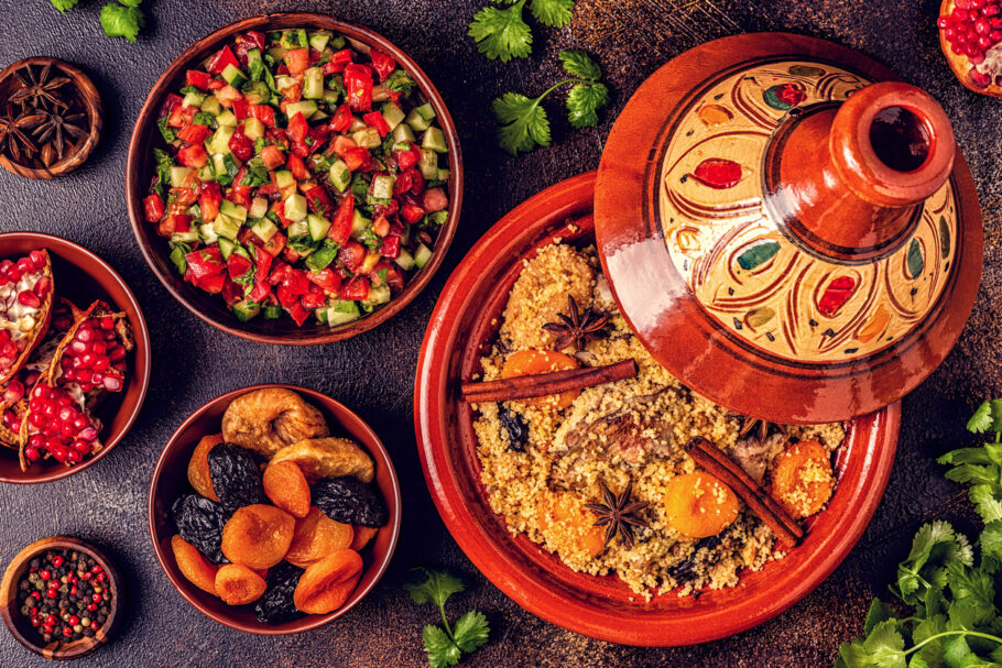 Tajine tradicional marroquino de frango com frutas secas e especiarias, vista de cima.