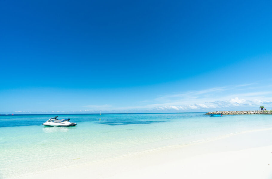 Linda praia tropical e céu azul na Ilha Maafushi, Maldivas, com jet ski.