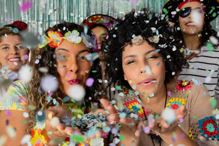 people blowing confetti while enjoying Brazil Carnival Party.