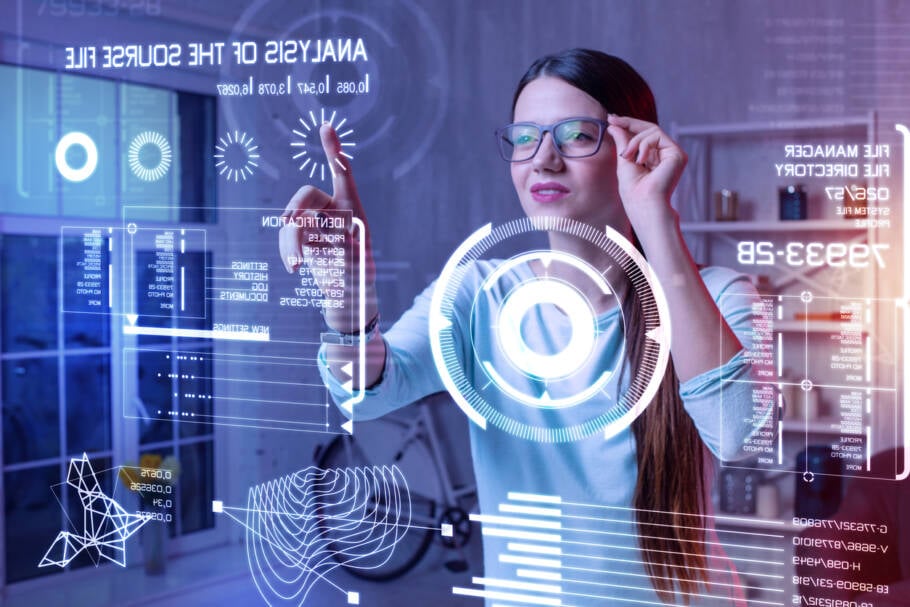 Progressive analyst. Young professional analyst touching her glasses and feeling satisfied while working at home with a help of her futuristic transparent device