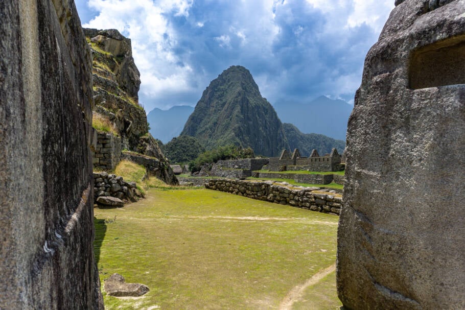 Vista panorâmica majestosa de Machu Picchu com Huayna Picchu ao fundo, antiga cidade inca no Peru, cercada por montanhas verdejantes e natureza espetacular