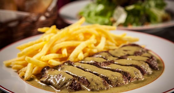 O prato principal é o entrecôte de 210g com suculento molho da Tia Nicole, batata frita fininha e crocante à vontade