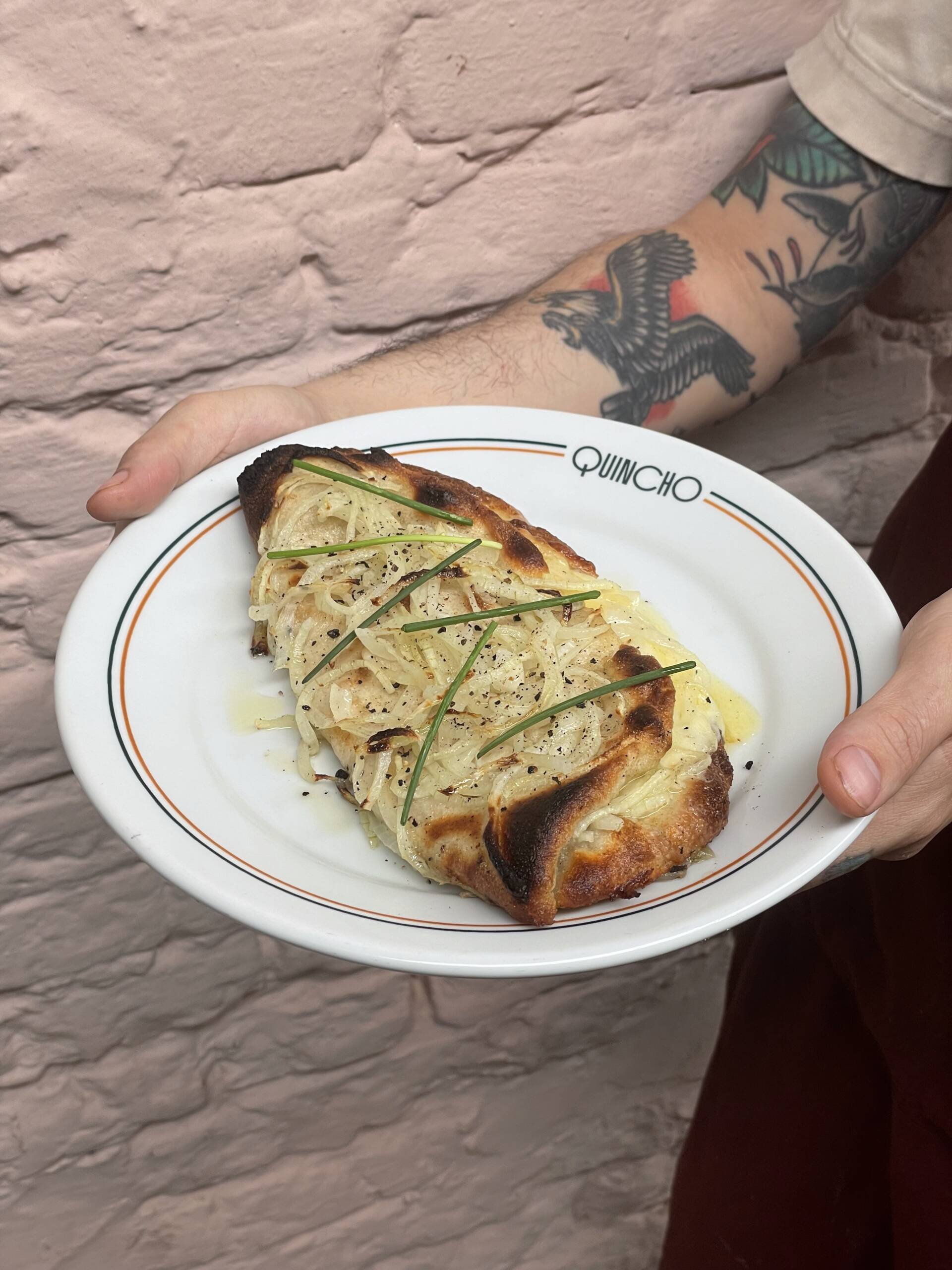 Fugazzeta (R$58) do Quincho: pizza argentina feita com massa napolitana recheada com provolone e muçarela, finalizada com muita cebola no forno a lenha