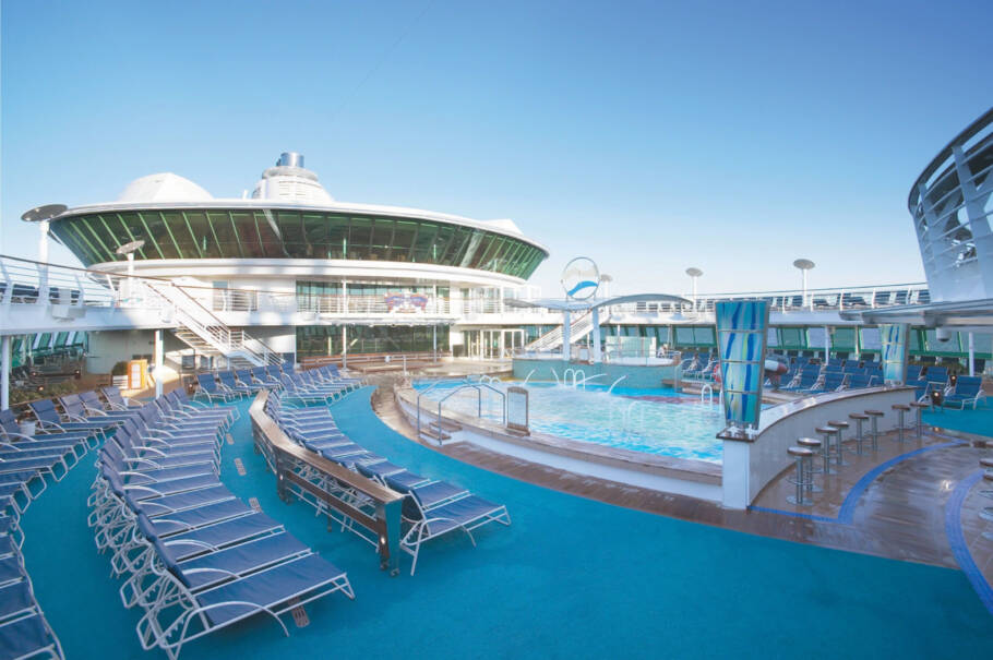 Piscina do Serenade of the Seas onde acontece cinema ao ar livre; no fundo, a balada Vortex, com paredes de vidro