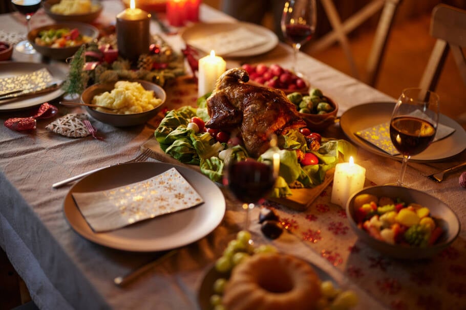 Close up of roasted dinner on dining table with place setting for Thanksgiving or Christmas.