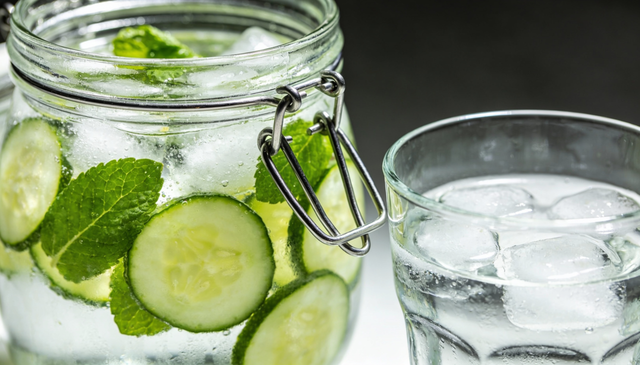 A água saborizada com pepino e hortelã é feita com água filtrada, rodelas de pepino fresco e folhas de hortelã fresca, podendo incluir gelo e rodelas de limão