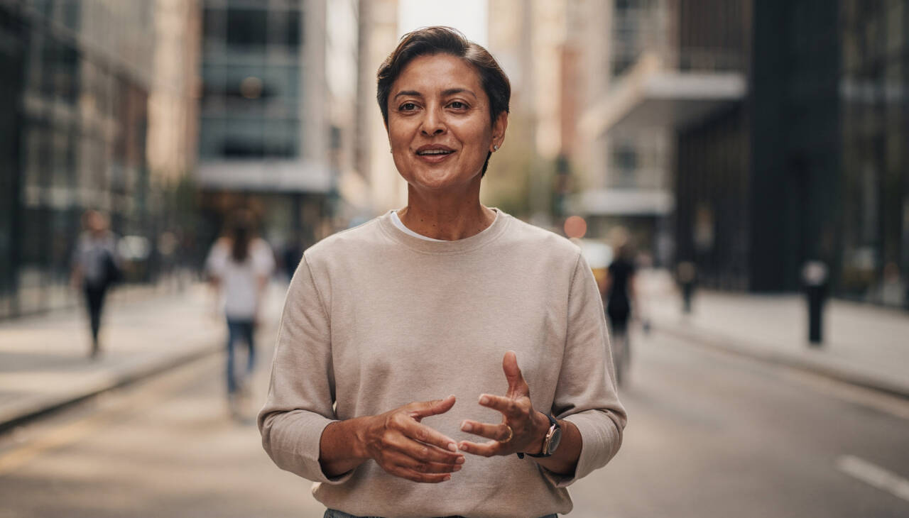 Pessoa sentada sozinha em ambiente calmo, mesa simples com caderno aberto e celular ao lado, expressão reflexiva e tranquila, momento de pausa antes de responder, cenário cotidiano realista que representa limites, autoconhecimento e decisões conscientes