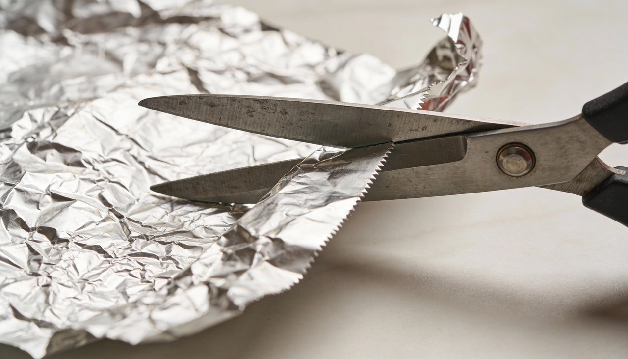 O processo de restauração começa ao dobrar uma folha de papel alumínio várias vezes até criar uma camada espessa e resistente para o contato inicial