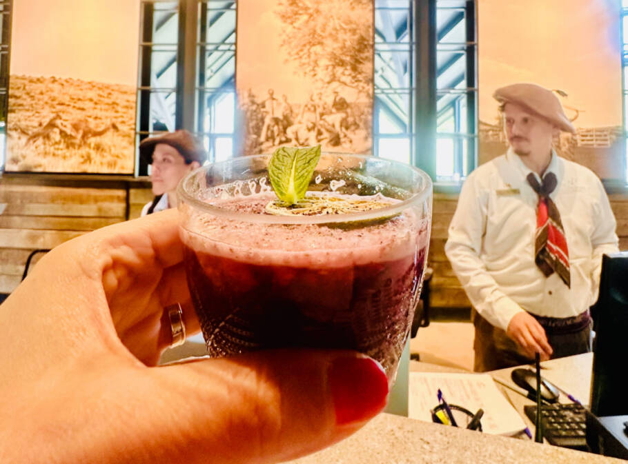 Drink de calafate dá boas-vindas aos visitantes; funcionários vestem roupas típicas da Patagônia