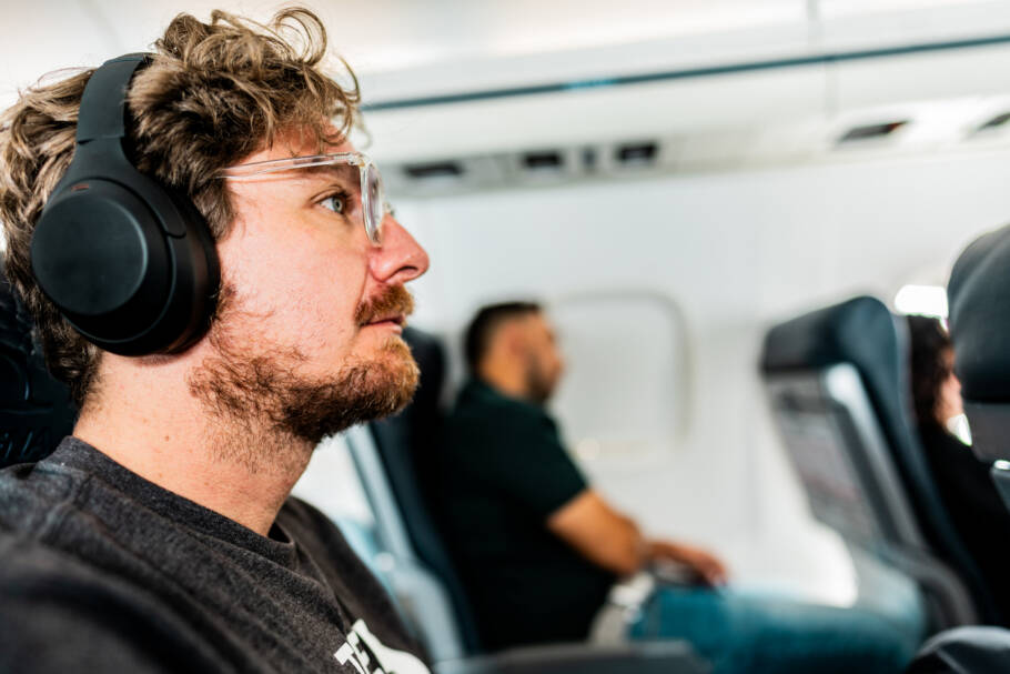 Mature man traveling by plane listening music with headphones
