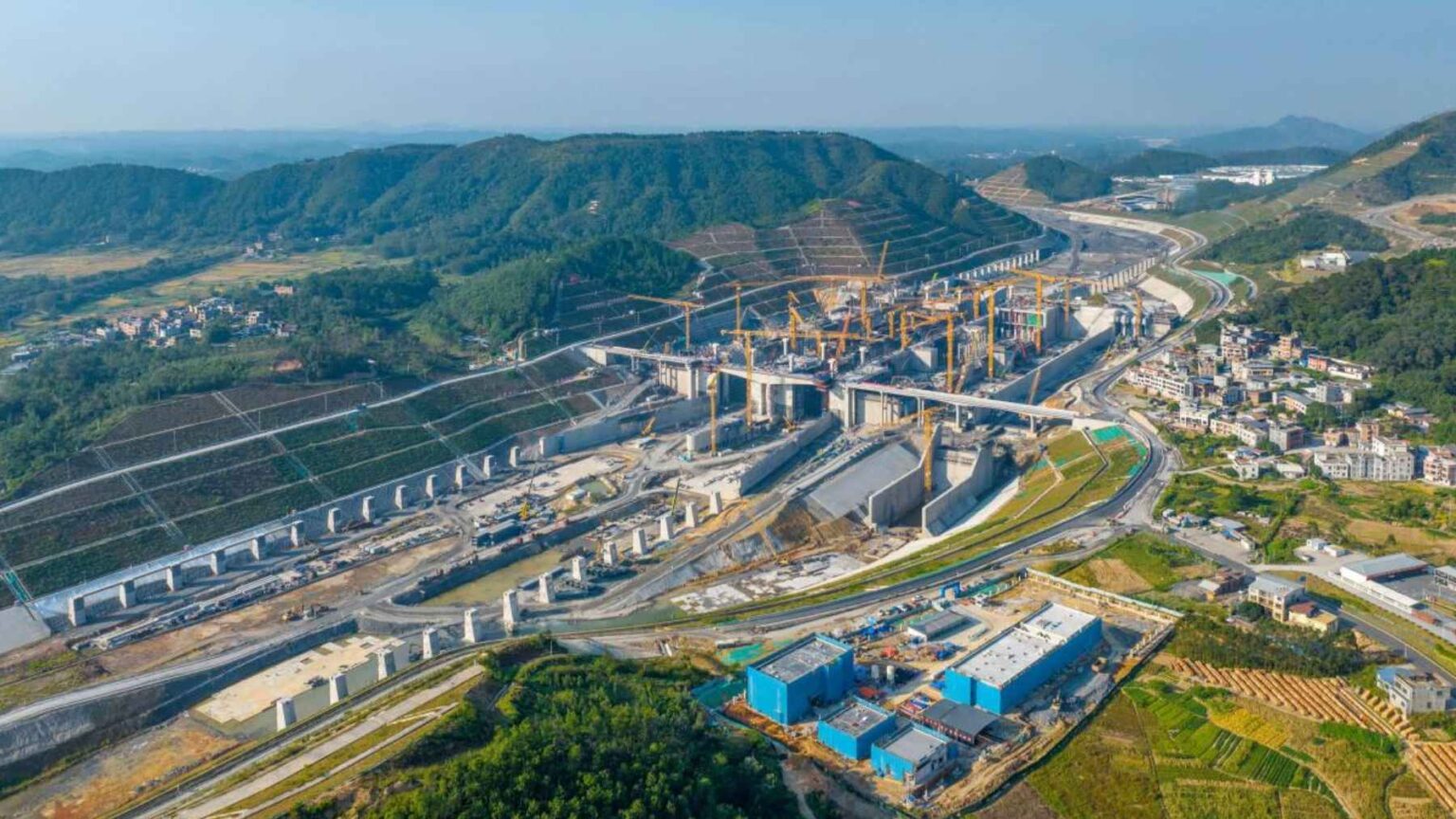 Trabalhadores e equipamentos pesados moldam o Canal Pinglu, um grande projeto de infraestrutura projetado para conectar rios interiores às rotas marítimas.