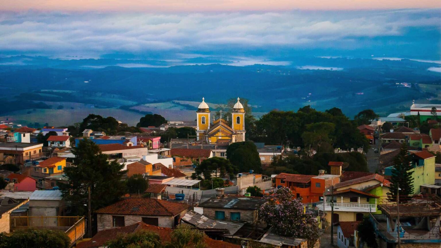 No alto do sul de Minas Gerais, uma pequena cidade brasileira ficou famosa por parecer ter crescido diretamente da montanha abaixo dela.