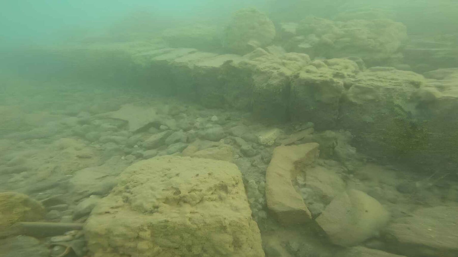 Um mergulhador recupera um grande recipiente de cerâmica do local submerso da Rota da Seda, oferecendo pistas sobre a vida cotidiana no assentamento medieval.
