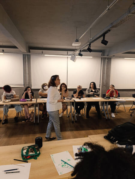 Participantes acompanham oficina durante uma edição do Encontro Mulheres nos Jogos Goiás, iniciativa que promove capacitação, diversidade e inclusão na indústria de games.