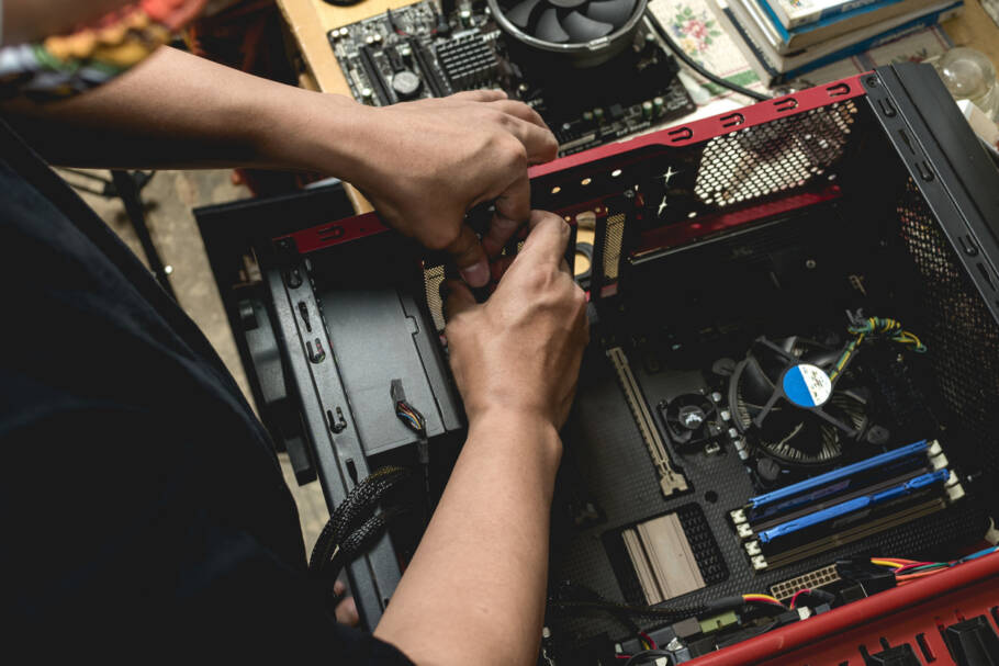 A computer technician assembles a desktop computer with new parts. Upgrading or replacing PC parts.