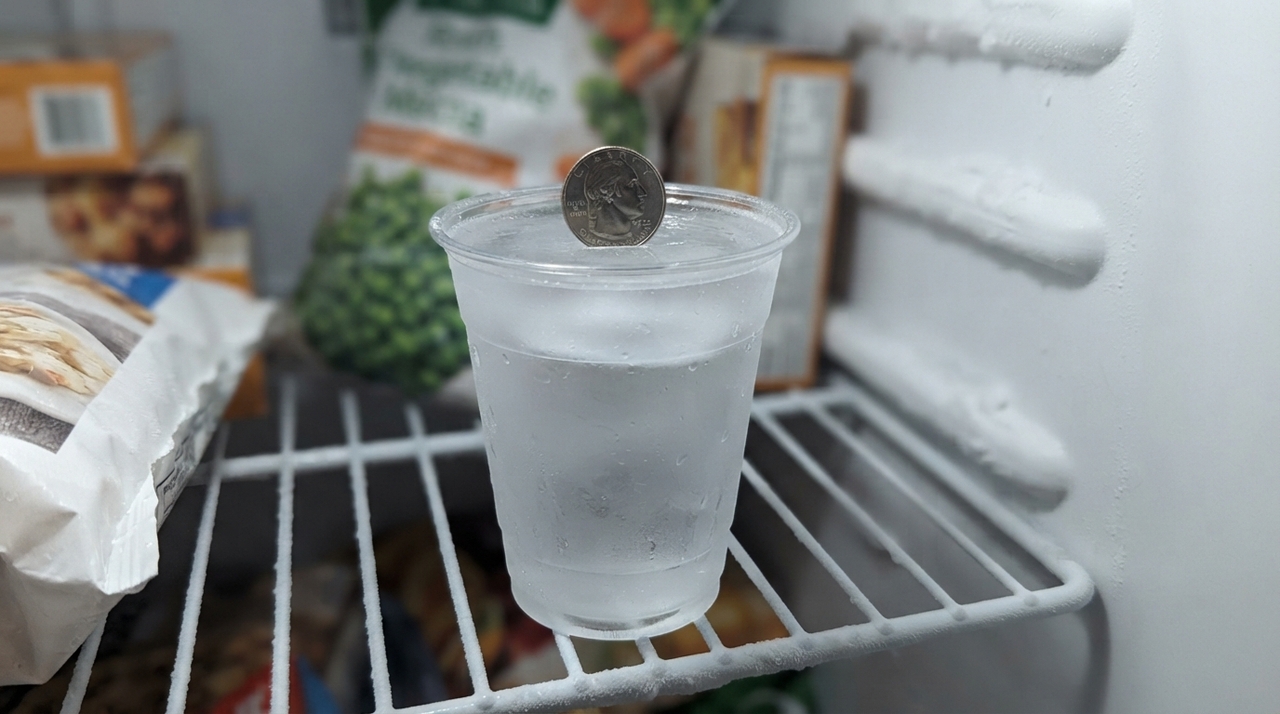 A ideia é criar um “marcador” dentro do congelador. Primeiro, enche-se um copo plástico com água e deixa-se congelar completamente.