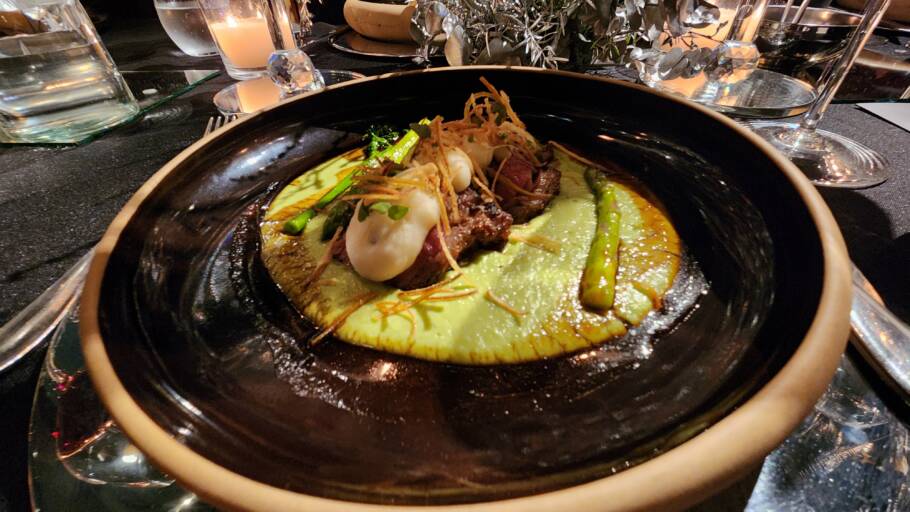 A maminha grelhada e marinada, servida com purê de ervilhas, mousse de batata, aspargos, brócolis-rama, crispy de alho-poró e molho demi-glace