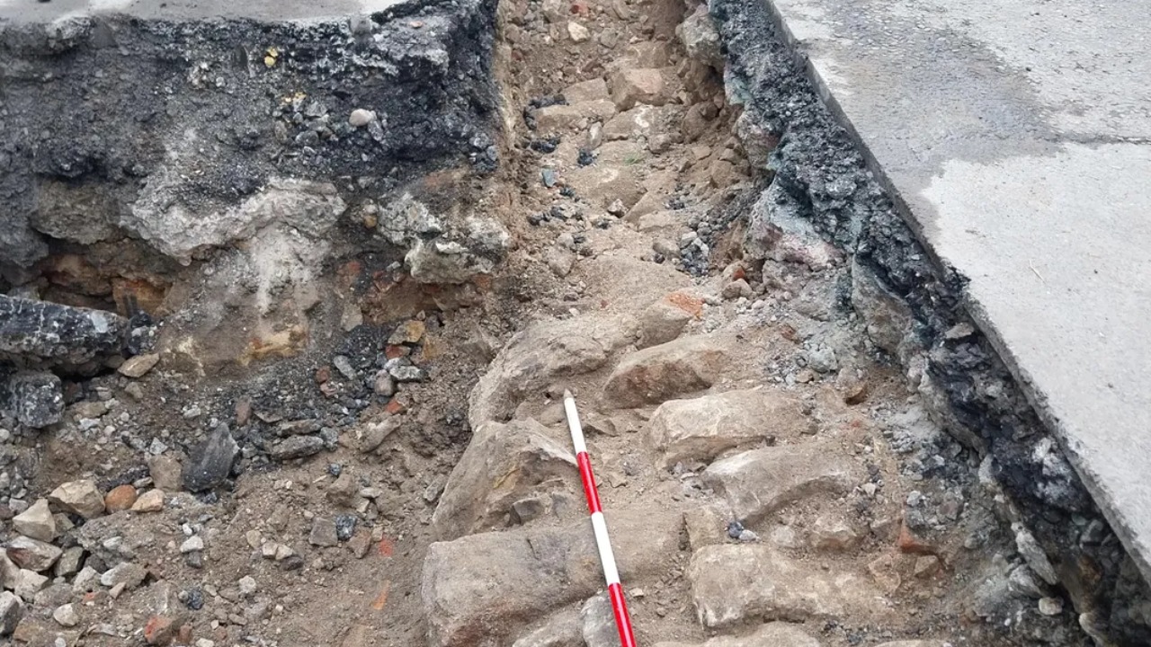 Reparo de asfalto em York que revelou paredes subterrâneas de hospital medieval.