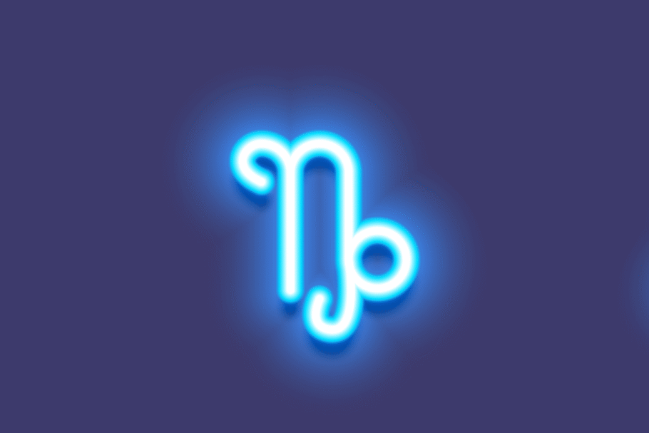 A imagem apresenta o símbolo do signo de capricórnio em branco, com um intenso efeito luminoso azul neon. O ícone está centralizado sobre um fundo azul-arroxeado escuro, criando uma aparência moderna e brilhante.
