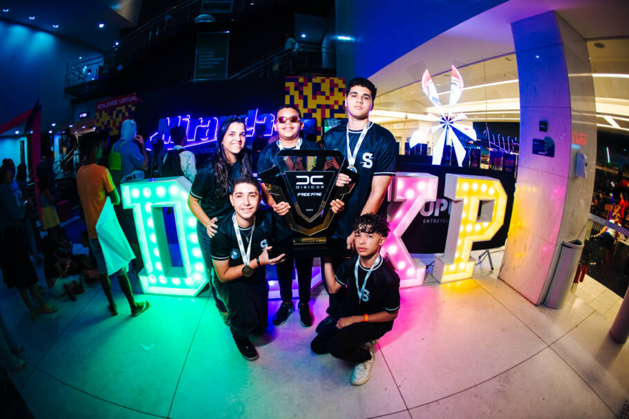 Jogadores com troféu da Digicom em evento de Free Fire.