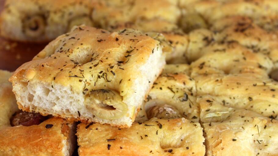 A receita da focaccia leva farinha, fermento, azeite, azeitonas e sal grosso e resulta em uma massa macia e saborosa