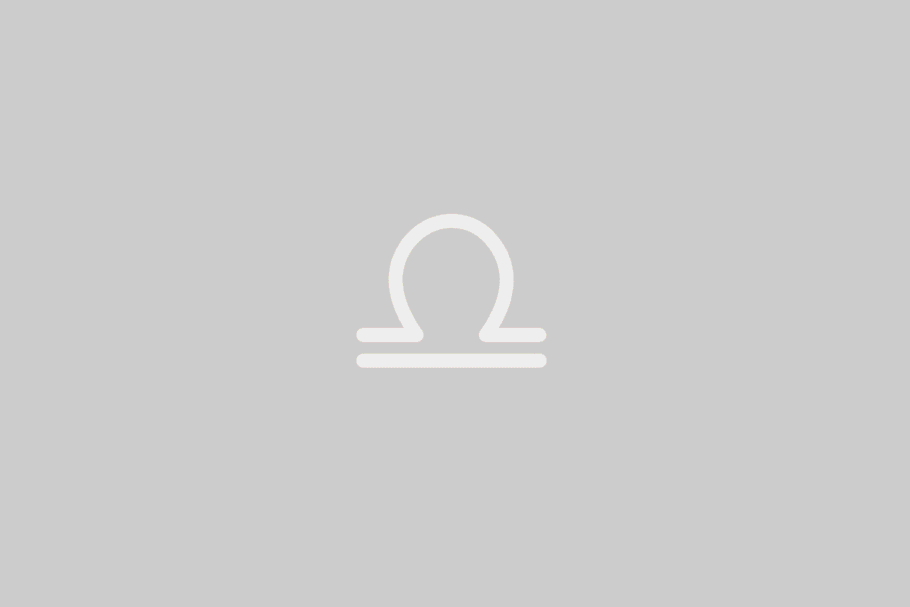 Imagem de fundo cinzento-bege liso. Apresenta ao centro o símbolo branco de Balança: uma linha reta horizontal inferior e, sobre ela, uma barra paralela com uma elevação em forma de semicírculo no meio