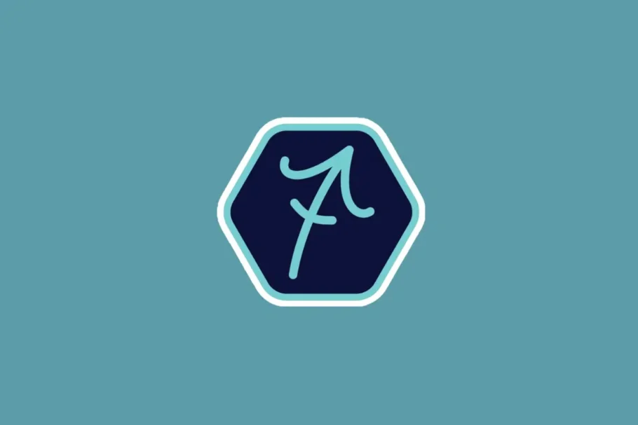 Ilustração minimalista do símbolo do signo de sagitário em tom azul-claro, centralizada dentro de um hexágono azul-escuro com borda branca e azul. O fundo da imagem é em um tom sólido de azul-turquesa