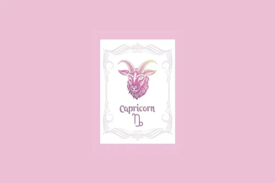 Um cartão branco com uma moldura ornamentada em rosa claro contém a ilustração de uma cabeça de cabra com um gradiente de roxo a laranja, e o texto "Capricorn" acima do símbolo da cabra, tudo sobre um fundo rosa sólido.