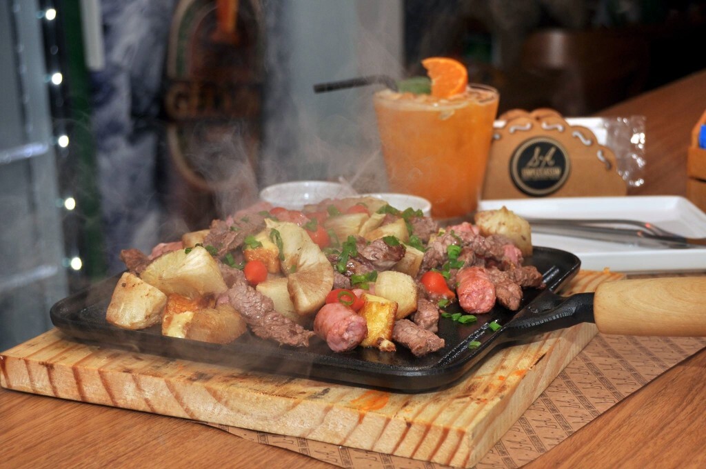 A Tábua Três Mosqueteiros (pedaços de alcatra, linguiça, mandioca frita, pimenta “biquinho” e queijo coalho) é o carro-chefe da casa