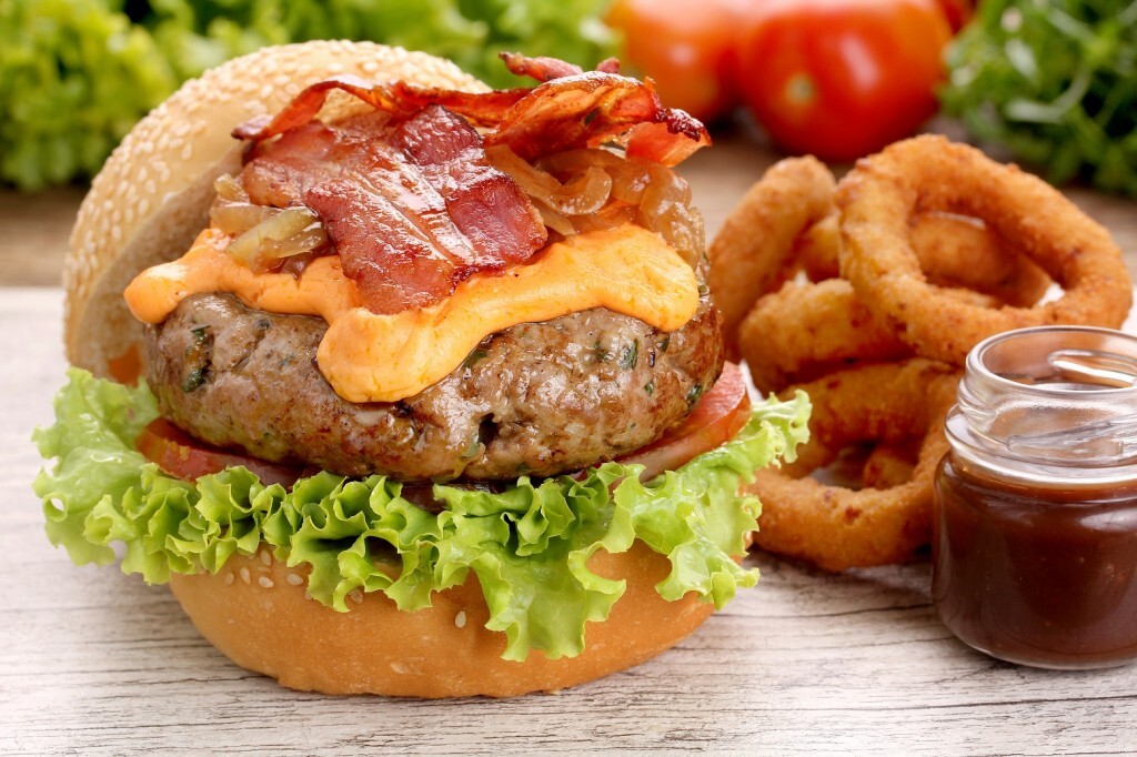 O delicioso hambúrguer vem acompanhado por Onion rings e molho barbecue