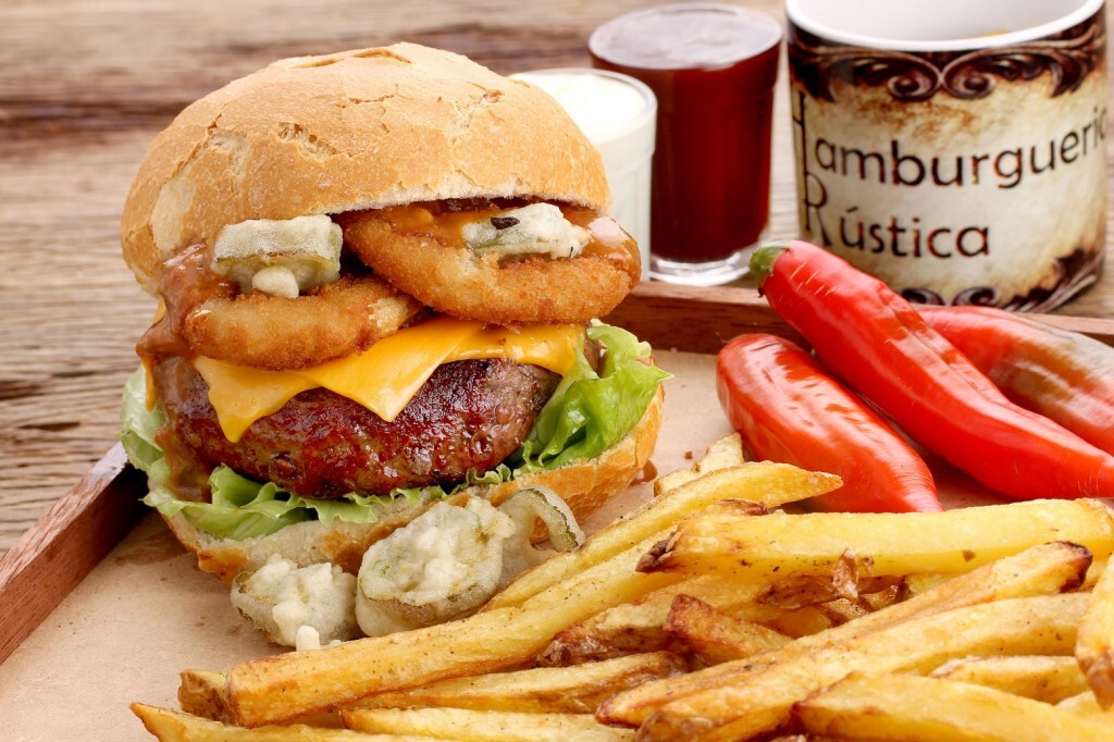 O sanduíche da Hamburgueria Rústica vem pedaços de jalapeño, alface americana, onion rings e molho picante