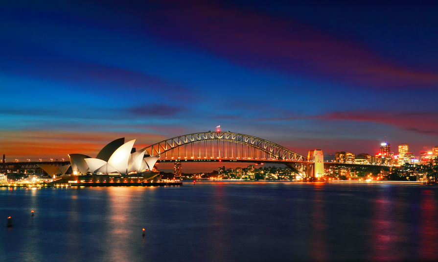 Sydney, Australia - April 8, 2014; Two of Sydney's famous icons, the Sydney Opera House and Sydney Harbour Bridge lit up at dusk after watching a magnificent sunset, the evening sky still aglow with some colour.