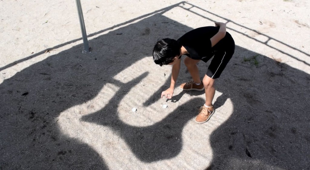 Criança brinca em pista feita a partir da luz solar